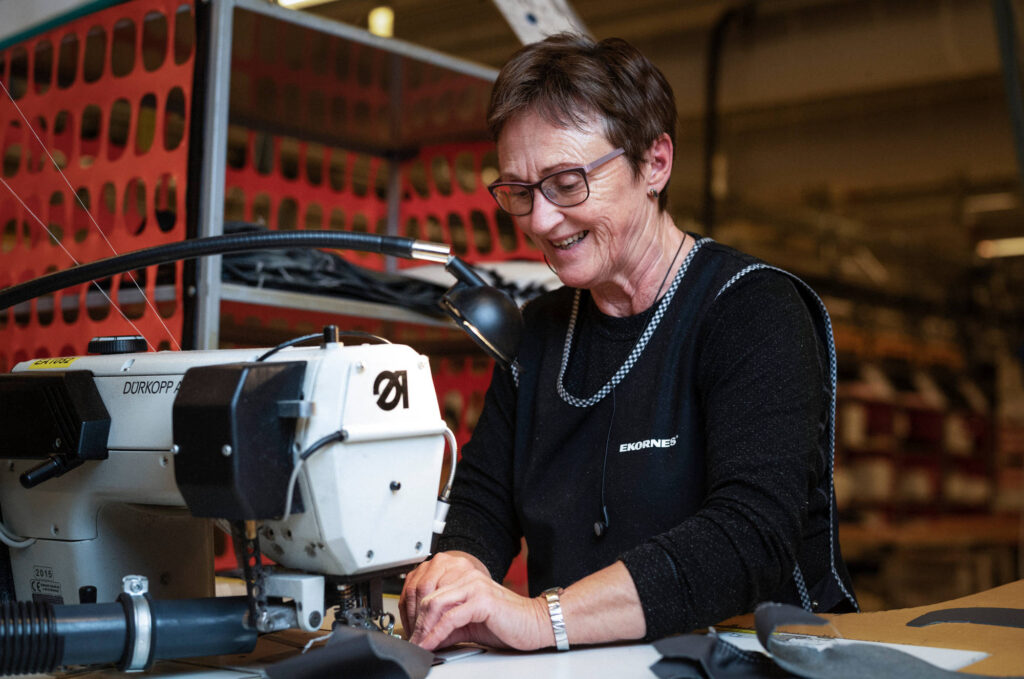 Smiling worker sewing